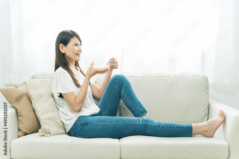 ソファでヨーグルトを食べる女性(笑顔)
ソファでヨーグルトを食べる女性(笑顔)