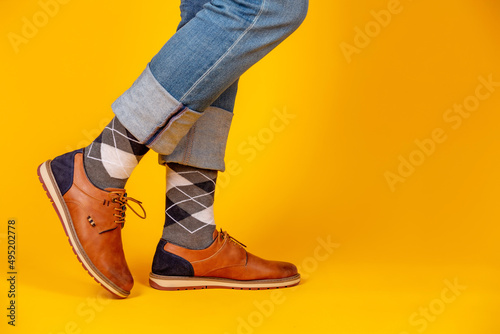 Beautiful shoes on the feet. Yellow background.