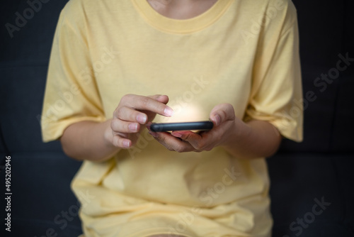 the woman Using a smartphone in the living room.Social media and digital online concept, woman using a smartphone. The concept of living on vacation and playing social media. Working From Home concept