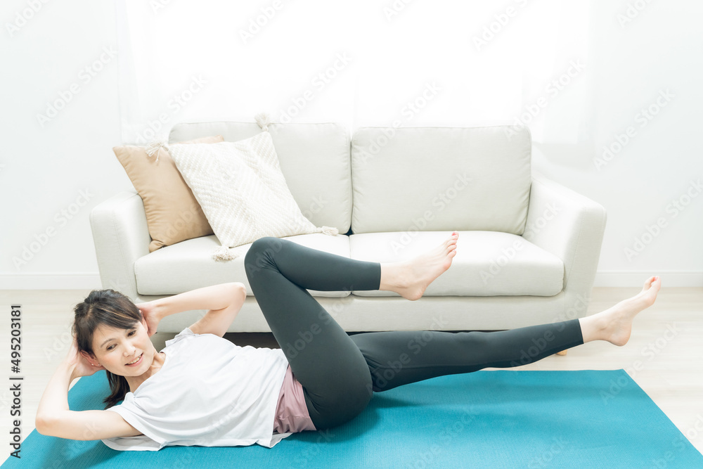 部屋でヨガをするミドル世代の女性
部屋でヨガをするミドル世代の女性