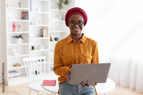Smiling millennial black woman entrepreneur working from home