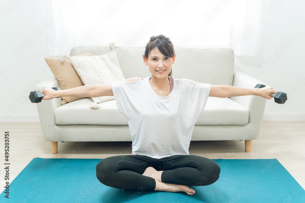 部屋で筋トレをする中高年女性
部屋で筋トレをする中高年女性
