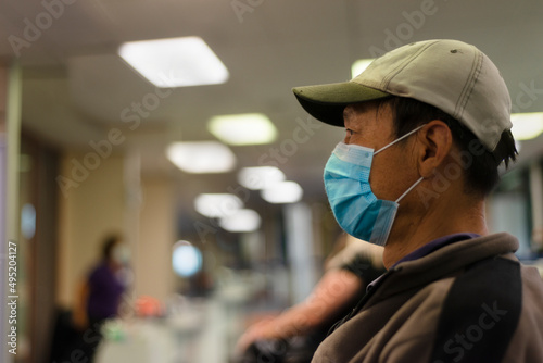 People wearing face mask and waiting at the clinic for coronavirus vaccination. People sitting 2 meters apart, Auckland.