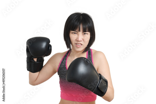 Young asian woman wearing boxing gloves winding up a punch, isolated on white background. © Ladanifer