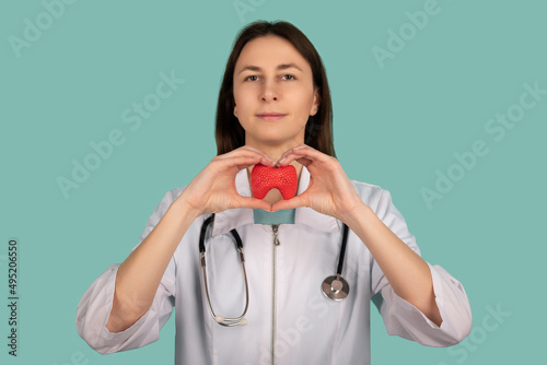 Female doctor with a stethoscope is holding mockup thyroid gland. Help and care concept photo