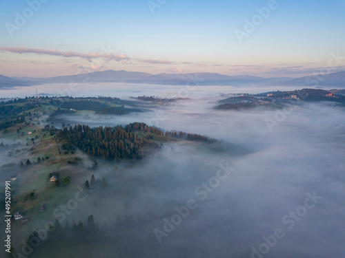 Flight over fog in Ukrainian Carpathians in summer. Mountains on the horizon. Aerial drone view. © Sergey