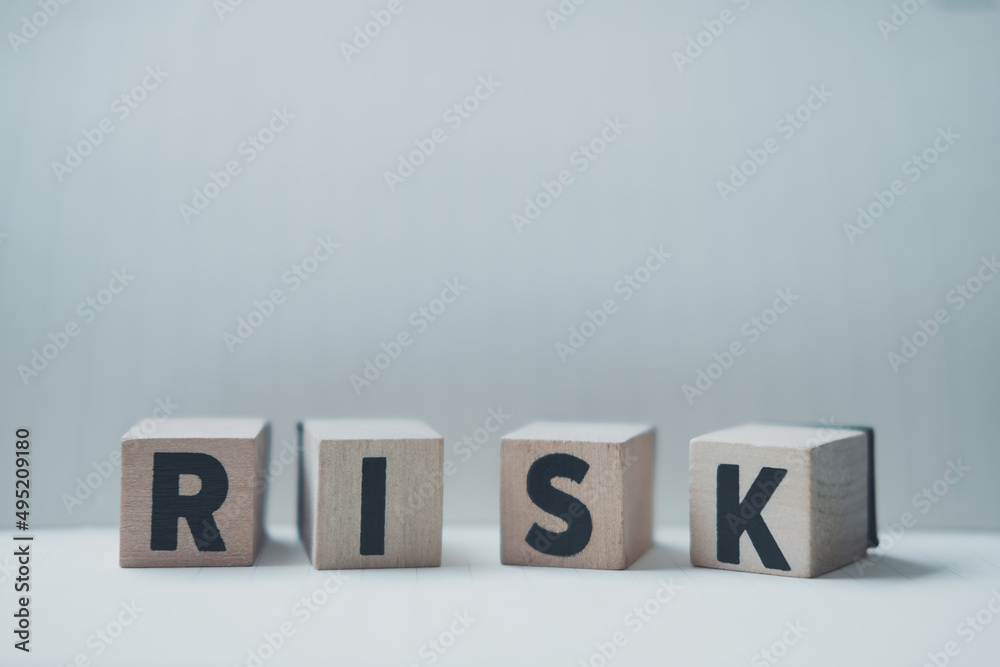 Obraz premium A row of four cubes on a table with a letter R, I, S, K on each cubes.