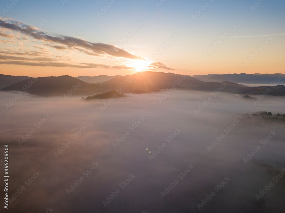 Sunrise over the fog in the Ukrainian Carpathians. Aerial drone view.