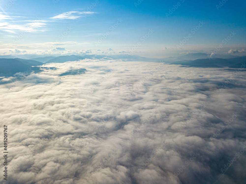 Fototapeta premium High flight above the clouds in the mountains. Aerial drone view.
