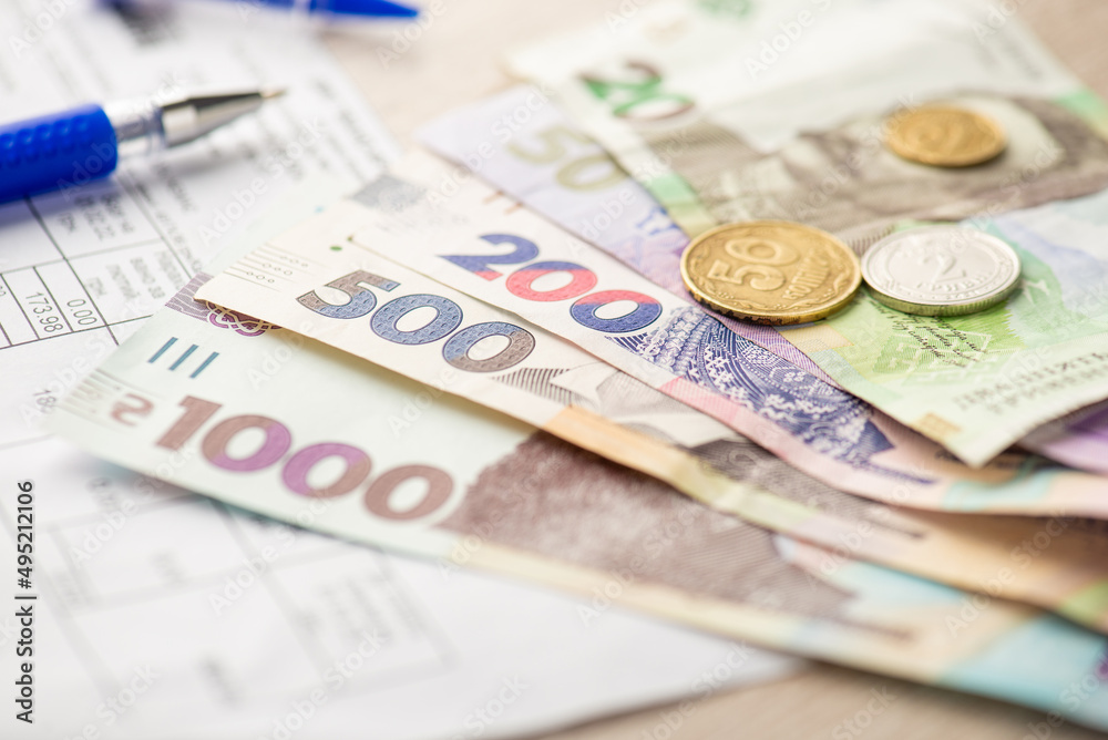 Close up photo of pen utility bills ukrainian hryvnia banknotes and coins Close up photo of pen utility bills ukrainian hryvnia banknotes and coins