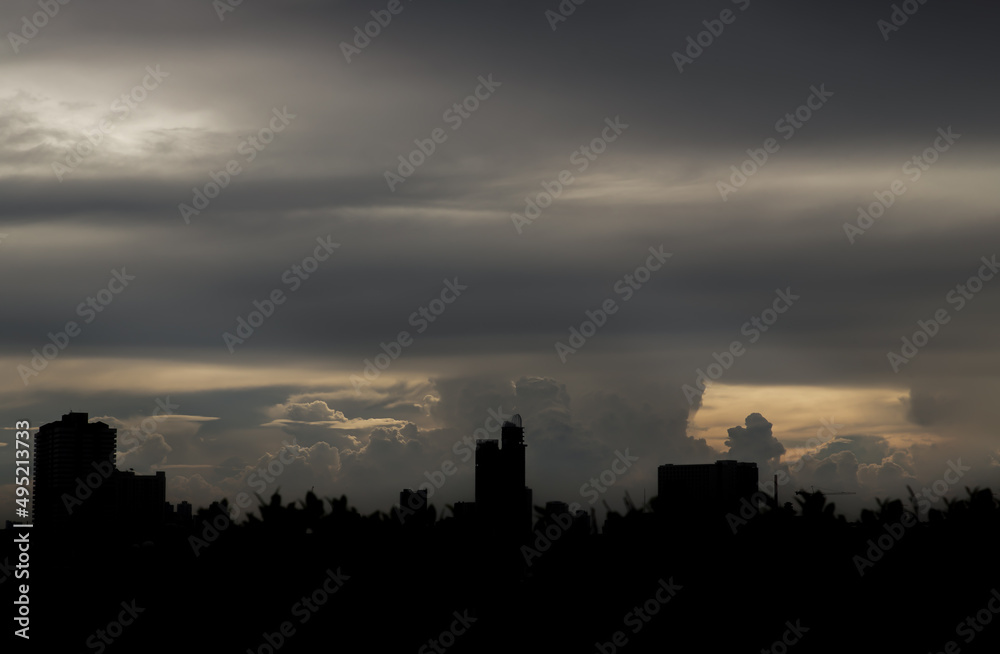 Beautiful clouds with sunshine through the cloud in the sky evening over large metropolitan city skyline. Copy space, No focus, specifically.