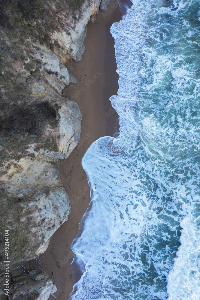 Aerial view to a beautiful wild rocky beach and big waves