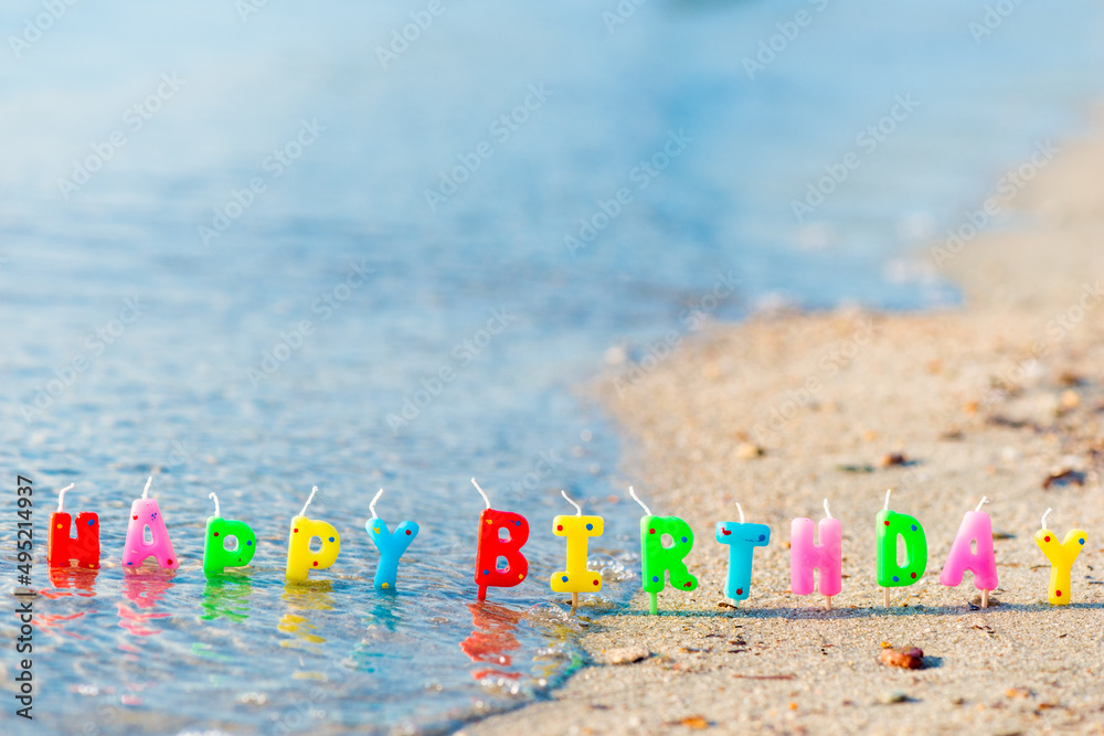 Happy birthday colorful candles on a beach Happy birthday colorful candles on a beach