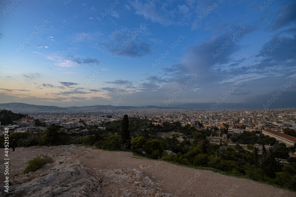 View of the city of Athens November 17, 2021: Evening landscape, blue sky with clouds, soft light. Picturesque view from the hill to the old town.