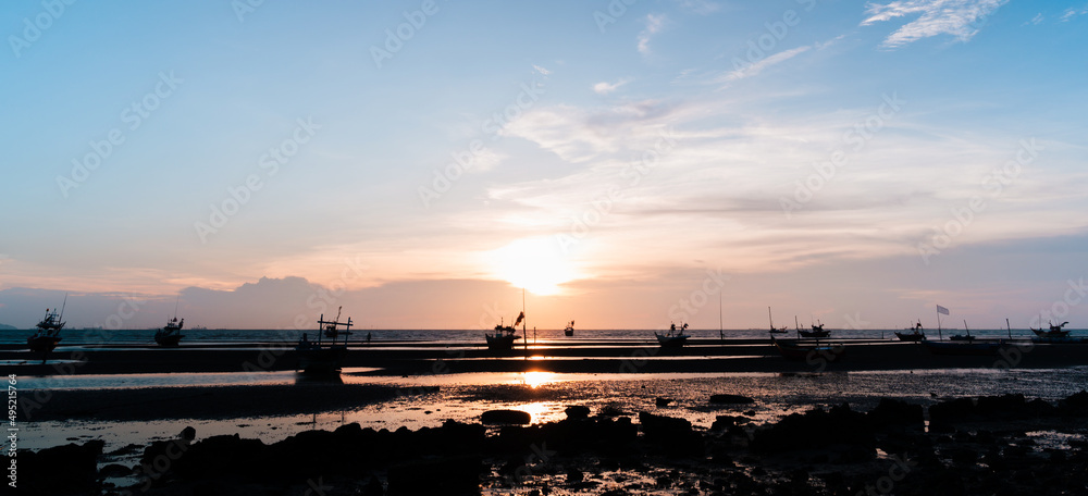 sunset over the harbor with fishing boat in Thailand.