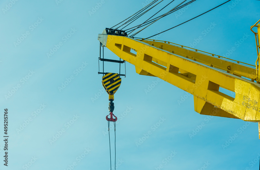 construction yellow crane jib against blue sky