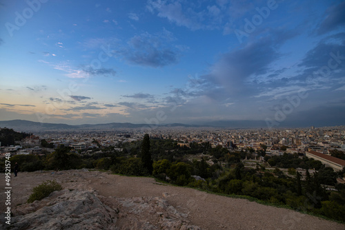 View of the city of Athens November 17, 2021: Evening landscape, blue sky with clouds, soft light. Picturesque view from the hill to the old town. © Sergei
