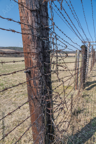 Memory of communism iron curtain in Cizov in Czech Republic village near border with Austria with barb wireded fence and anti-tank obstacles photo