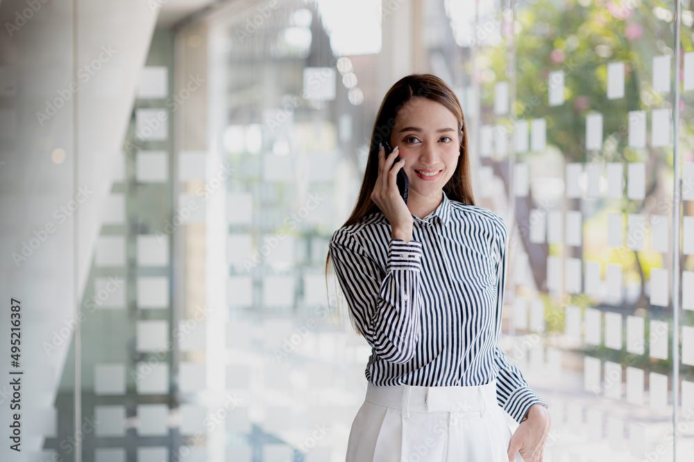 Asian woman talking on the phone, she is a salesperson in a startup company, she is calling customers to sell products and promotions. Concept of selling products through telephone channels.