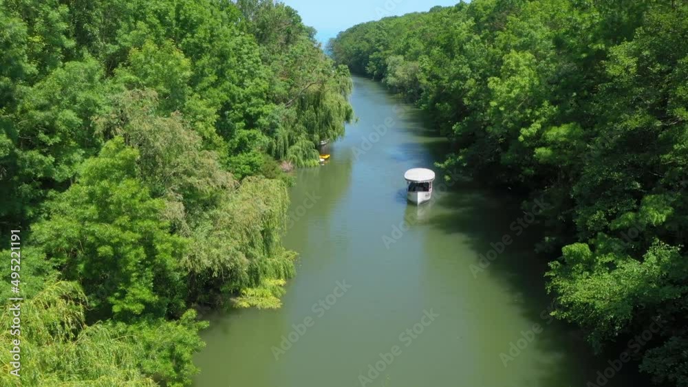 Beautiful view of Kamchiya river and tropical rainforest in summer day. The drone is flying on the river. Aerial landscape. A lone boat is moving in the opposite direction.Picturesque view from above Beautiful view of Kamchiya river and tropical rainforest in summer day. The drone is flying on the river. Aerial landscape. A lone boat is moving in the opposite direction.Picturesque view from above