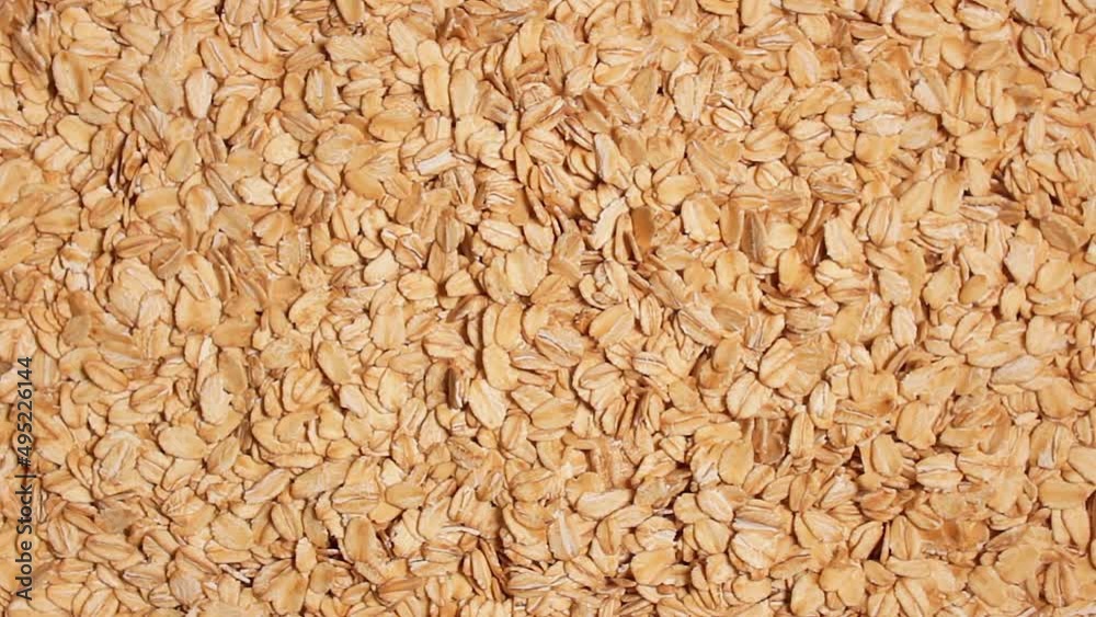 Oat Flakes Background Slowly Rotating Left - Top View. Scattered Dry Oat Flakes. Healthy Breakfast and Diet Eating Ingredients Oat Flakes Background Slowly Rotating Left - Top View. Scattered Dry Oat Flakes. Healthy Breakfast and Diet Eating Ingredients