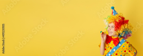 Leinwand Poster Funny kid clown against yellow background