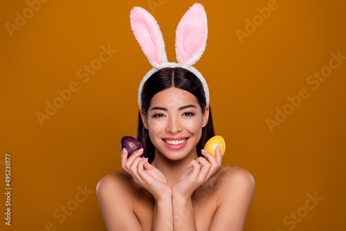 Closeup photo of asian ethnicity pretty girl wear easter fluffy ears hold painted eggs prepare dinner isolated pastel background