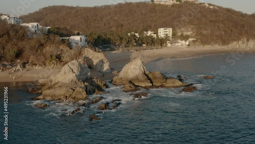 Winter sunset on pacific coastline. Hotels and villas near rocky beaches