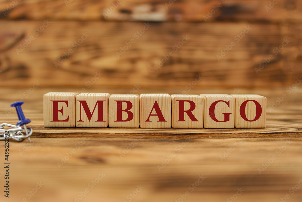 Fototapeta premium Embargo. Word on wooden blocks. Isolated on a gray background. Business. Politics. Economy. Conflict between Ukraine and Russia. Crisis, poverty, starvation. Conceptual.