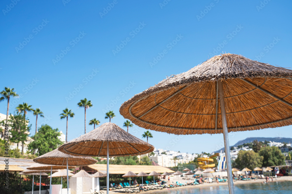 Beach umbrellas and deck chairs on the beach at a tropical resort for summer holidays