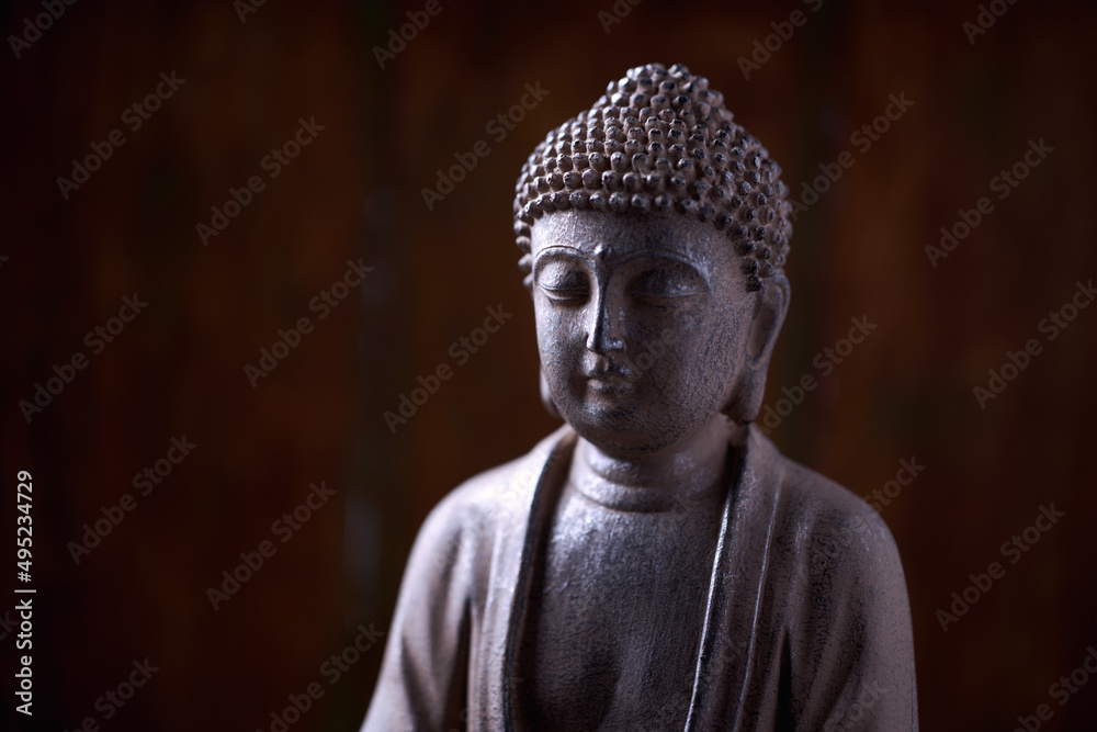 Meditating Buddha Statue on dark wooden background. Close up. Copy space.                        