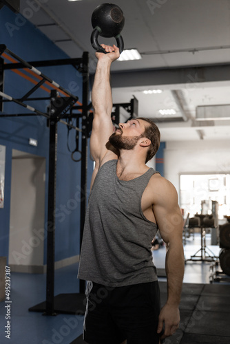 man doing exercises with kettlebell in the gym