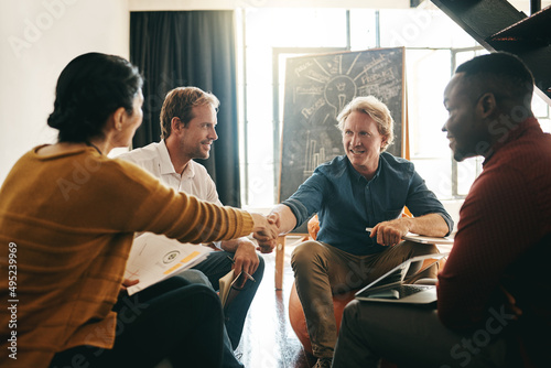In it for the betterment of business. Shot of designers shaking hands during a meeting in an office.