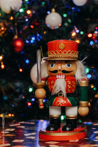 Nutcracker wooden toy on the background of festive Christmas lights. Nutcracker figurine. Bokeh. Christmas. New Year © Лилия Люцко
