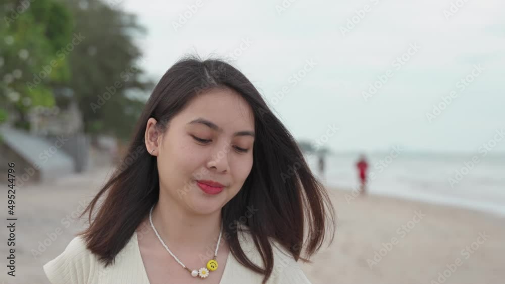 Beautiful young asian woman walking and smiling on tropical beach in summer vacation Beautiful young asian woman walking and smiling on tropical beach in summer vacation