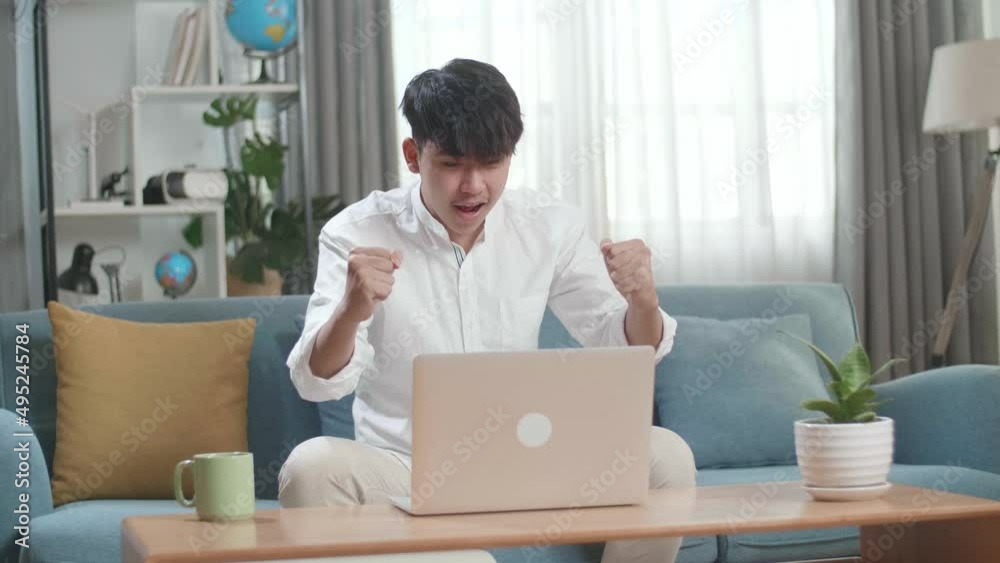 Happy Asian Man Celebrating While Using Laptop Computer In The Living Room
Happy Asian Man Celebrating While Using Laptop Computer In The Living Room