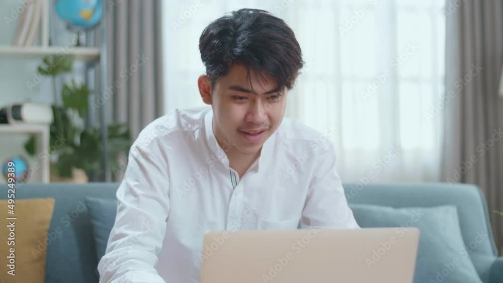 Smiling Asian Man Sitting On Sofa Use Laptop Computer In The Living Room
Smiling Asian Man Sitting On Sofa Use Laptop Computer In The Living Room