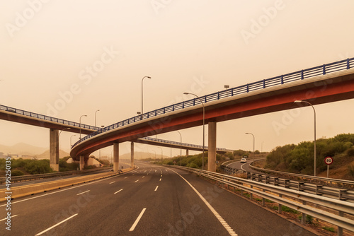 Highway with bridges at various levels on a day with Saharan dust in the environment, creating a foggy atmosphere.