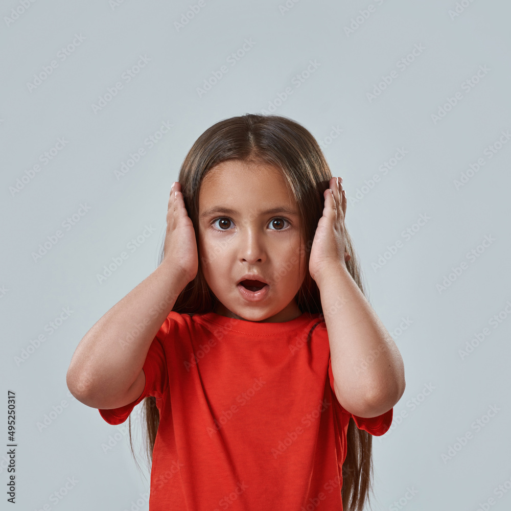 Frightened little girl with open mouth hold head Frightened little girl with open mouth hold head