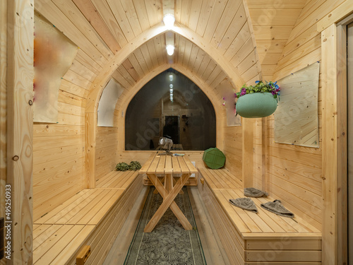 Wooden interior of modern bathhouse. Table and benches.