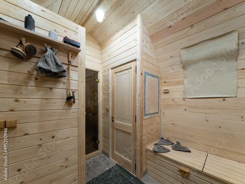 Wooden interior of modern bathhouse. Door to sauna.