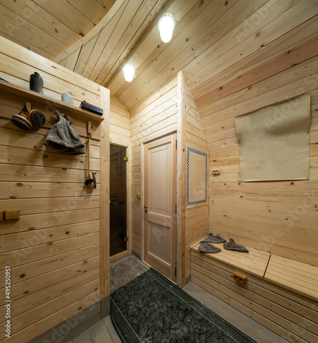 Wooden interior of modern bathhouse. Door to sauna.