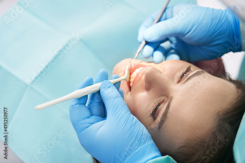 Dentist examining woman teeth in dental clinic