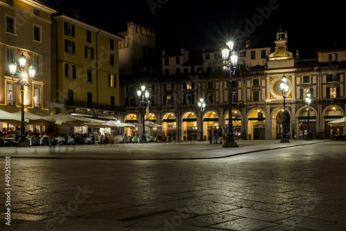 Old pedestrian square at the italian Brescia city with the Clock tower on the background by night