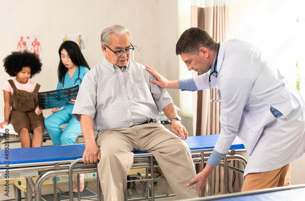 Obraz premium doctor examining the knee and leg after surgery of asian senior old man patient suffering from pain in knee on bed in medical office room at hospital .