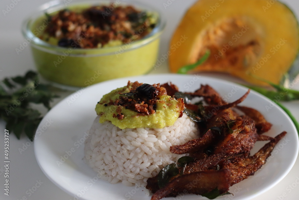 Kerala meals with boiled matta red rice, coconut based pumpkin curry and anchovy fry