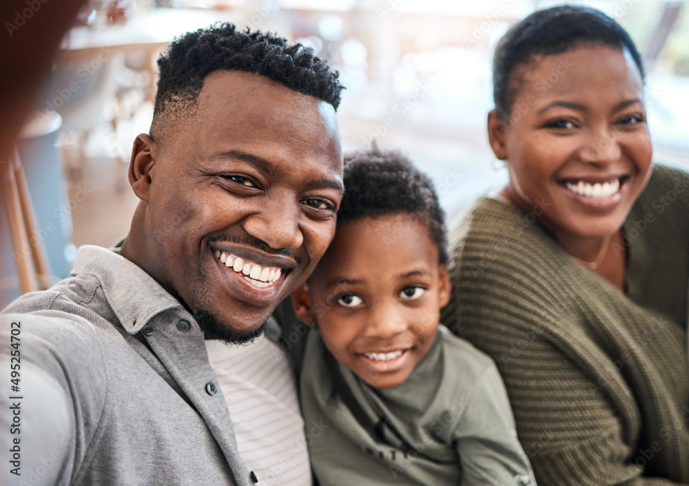 Im the proudest dad in the world. Shot of a happy young family taking selfies on the sofa at home.