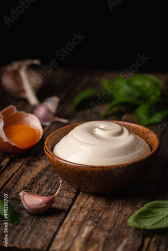 Bowl of Homemade mayonnaise sauce with ingredients and herbs for cooking