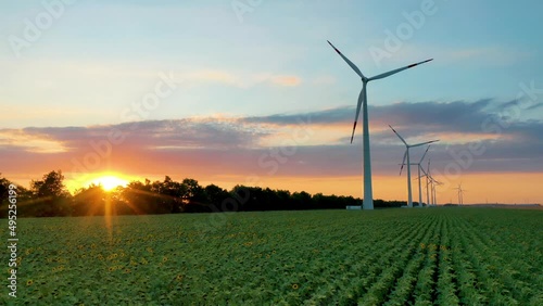 Wind power station. Green energy. A renewable source of powerful electrical energy. Ecology. Sunset. Aerial photography video shooting. Wind turbine. Generator.  photo