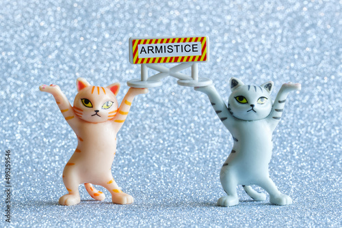 Fotografie Two funny toy kittens are holding a sign that says armistice